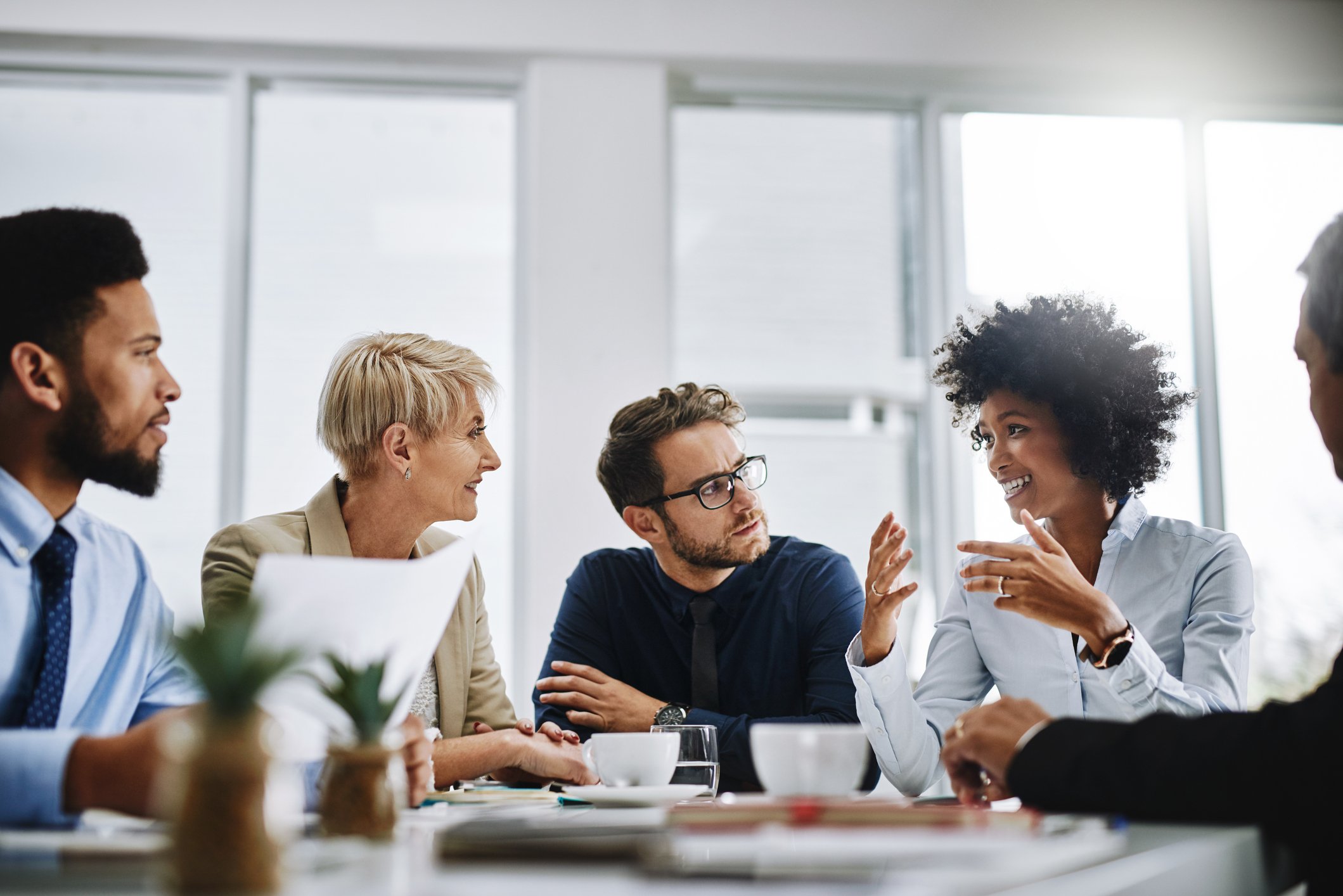 group-of-coworkers-sitting-at-table-having-business-meeting-over-coffee